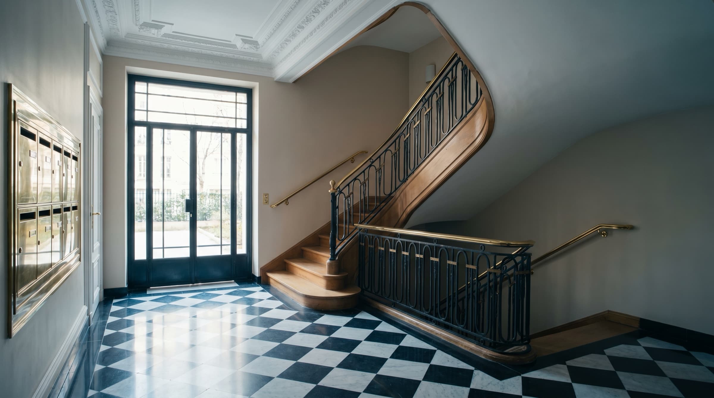 Hall d'immeuble haussmannien parisien, marbre noir et blanc.